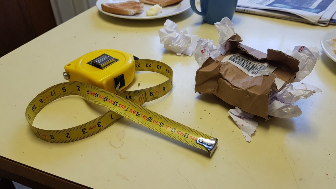 A tape measure wrapping past zero next to an overstuffed sleeve